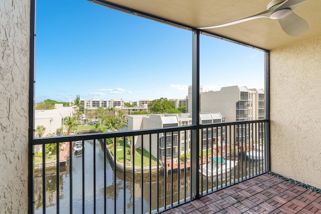 balcony with a water view and ceiling fan