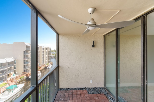 balcony with ceiling fan and a water view