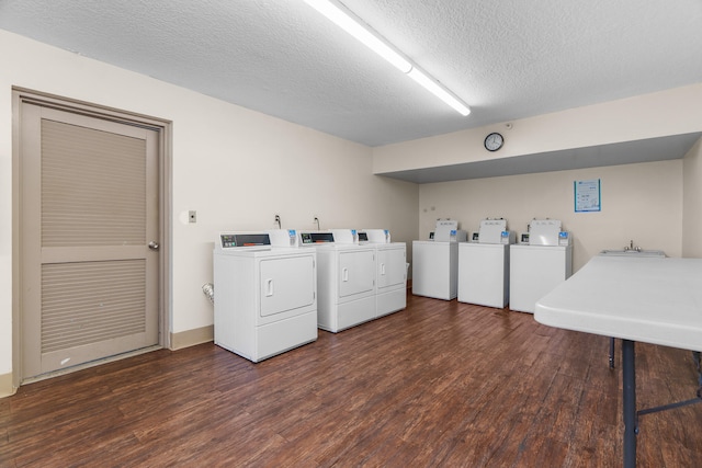 laundry room with washing machine and dryer, dark hardwood / wood-style flooring, and a textured ceiling