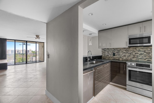 kitchen with ceiling fan, sink, decorative backsplash, light tile patterned flooring, and appliances with stainless steel finishes