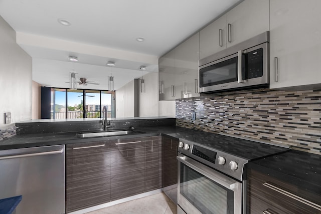 kitchen featuring sink, ceiling fan, light tile patterned floors, appliances with stainless steel finishes, and tasteful backsplash