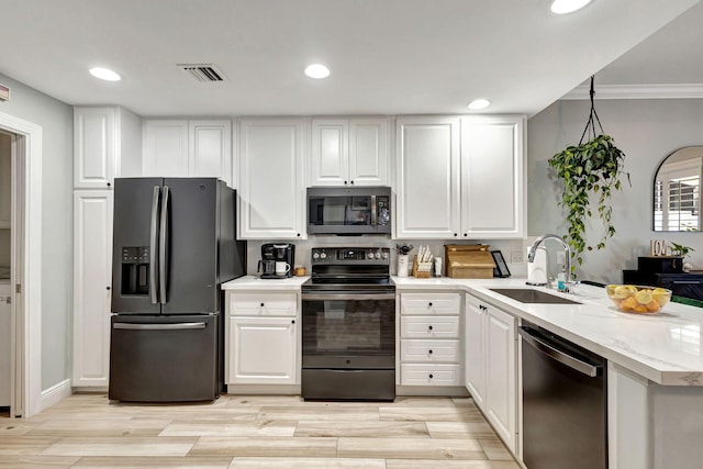 kitchen featuring light wood-type flooring, ornamental molding, stainless steel appliances, sink, and white cabinetry