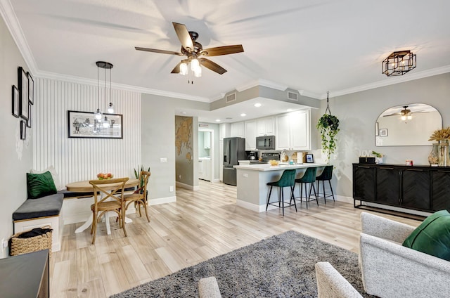 living room with light wood-type flooring, ceiling fan, and crown molding