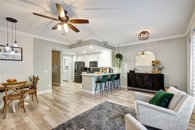 living room featuring ceiling fan, light wood-type flooring, and ornamental molding