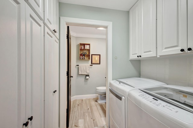 clothes washing area with light hardwood / wood-style floors, washing machine and dryer, and ornamental molding