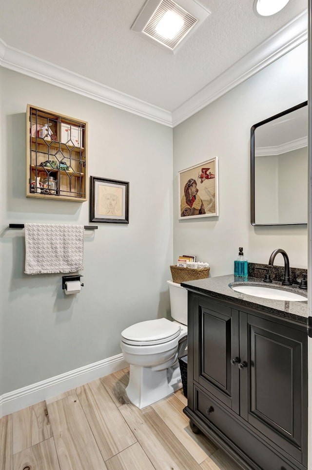 bathroom featuring hardwood / wood-style flooring, toilet, vanity, and ornamental molding