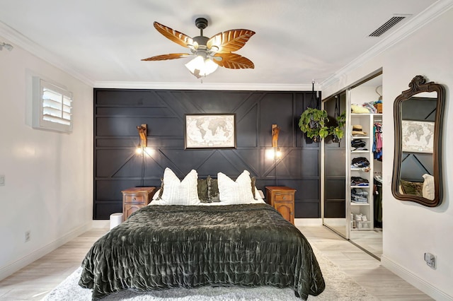 bedroom featuring a closet, ceiling fan, crown molding, and light hardwood / wood-style flooring