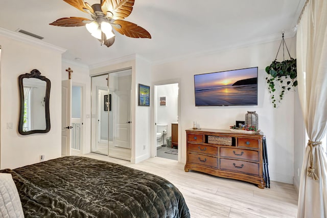 bedroom featuring ensuite bathroom, ceiling fan, light wood-type flooring, ornamental molding, and a closet