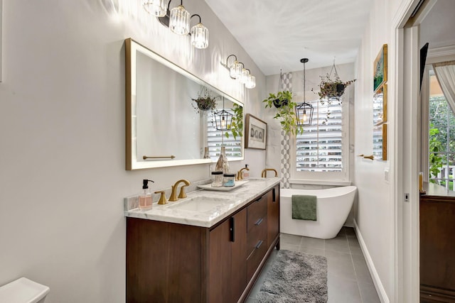 bathroom with a tub to relax in, tile patterned floors, and vanity