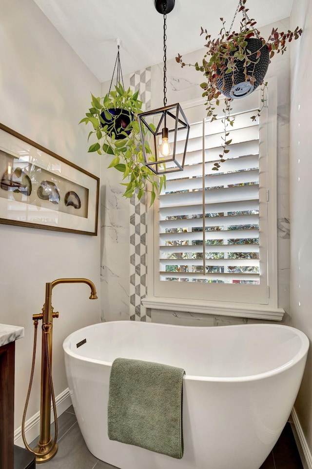 bathroom featuring tile patterned floors, plenty of natural light, vanity, and a bath