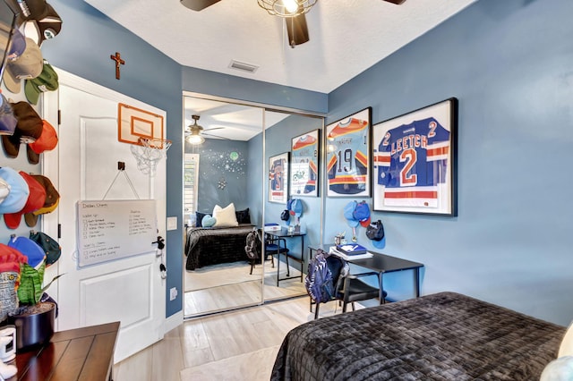 bedroom with ceiling fan, a closet, wood-type flooring, and a textured ceiling