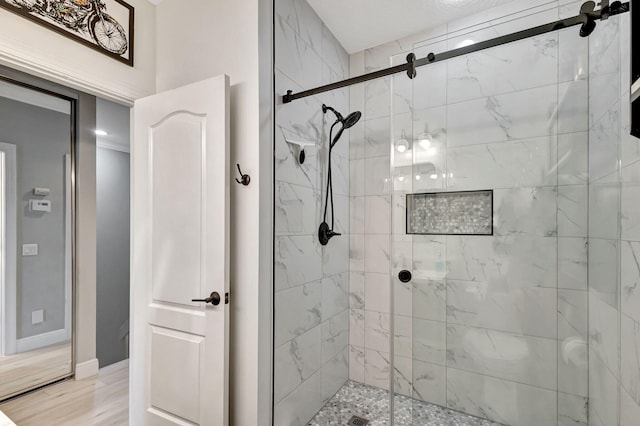 bathroom with hardwood / wood-style flooring and an enclosed shower