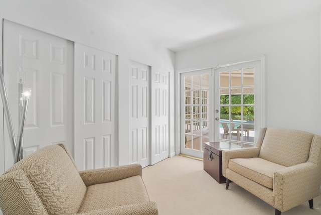 living area featuring light carpet and french doors