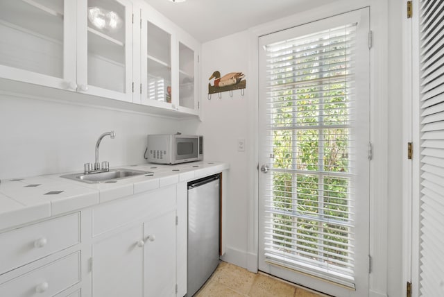 bar featuring white cabinets, a wealth of natural light, and appliances with stainless steel finishes