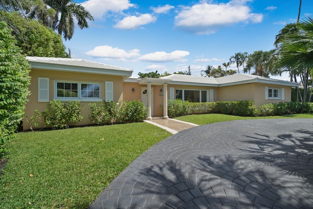 ranch-style home featuring a front lawn