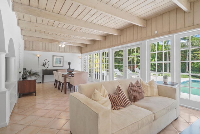 living room featuring light tile patterned floors, decorative columns, and plenty of natural light