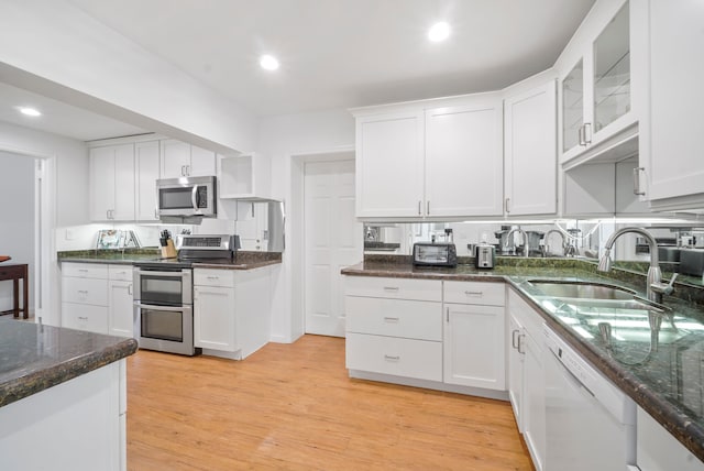 kitchen with white cabinets, stainless steel appliances, light hardwood / wood-style flooring, and sink