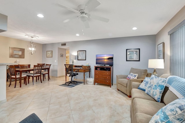 living room featuring light tile patterned floors and ceiling fan with notable chandelier