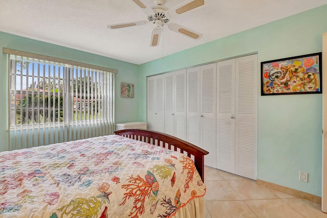 tiled bedroom with a closet, ceiling fan, and a textured ceiling