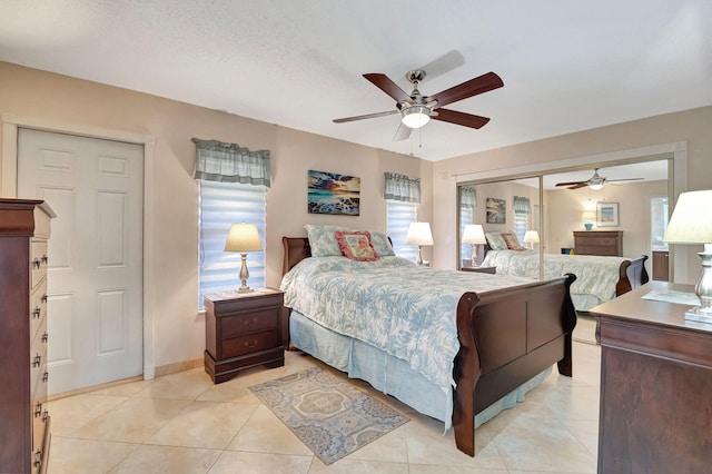 tiled bedroom featuring multiple windows and ceiling fan