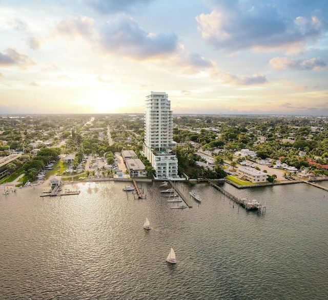 aerial view at dusk featuring a water view