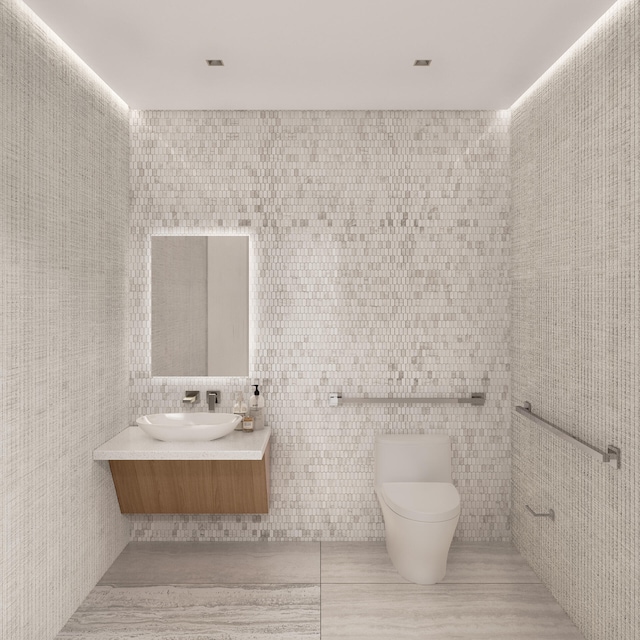 bathroom with tile patterned flooring, vanity, toilet, and tile walls