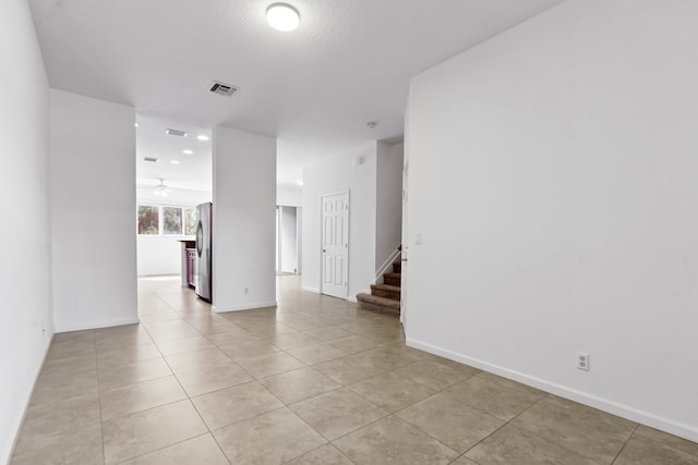 empty room featuring light tile patterned floors and ceiling fan