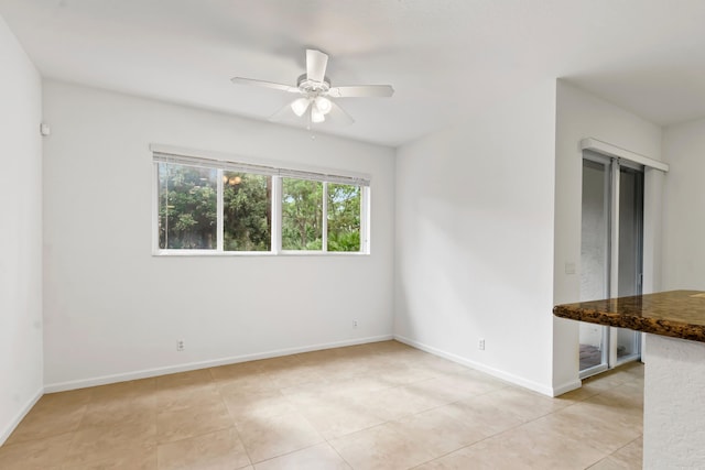 tiled empty room with ceiling fan