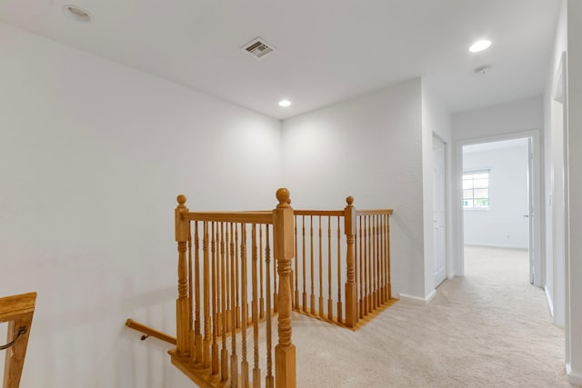 corridor featuring light colored carpet