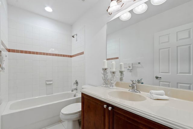 full bathroom featuring tile patterned floors, vanity, tiled shower / bath combo, and toilet