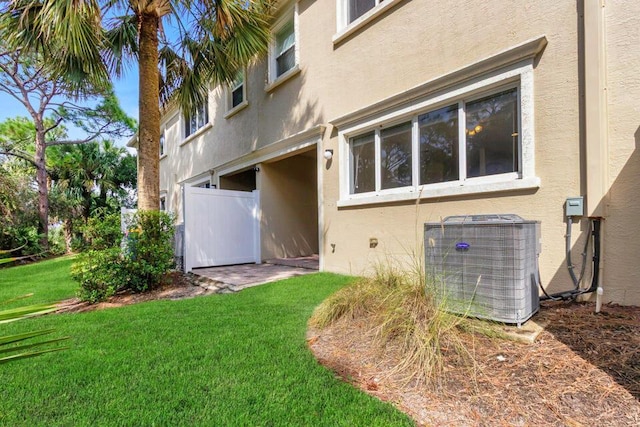 6120 SE Portofino Cir, Hobe Sound, FL 33455 - back of house with central AC, stucco siding, and a lawn
