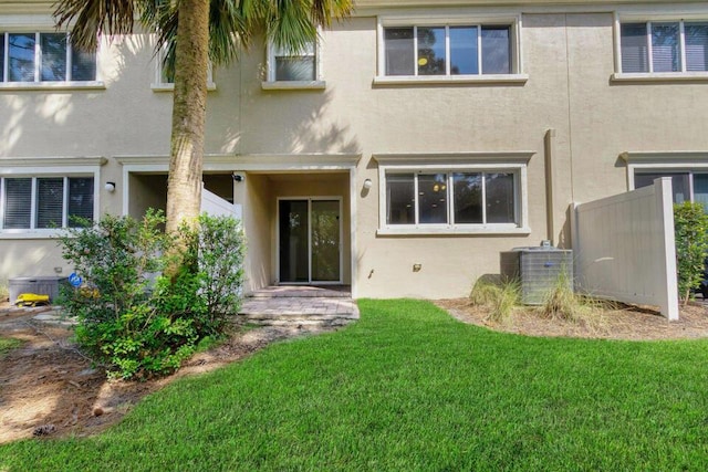 6120 SE Portofino Cir, Hobe Sound, FL 33455 - rear view of house featuring stucco siding, a yard, and central air condition unit