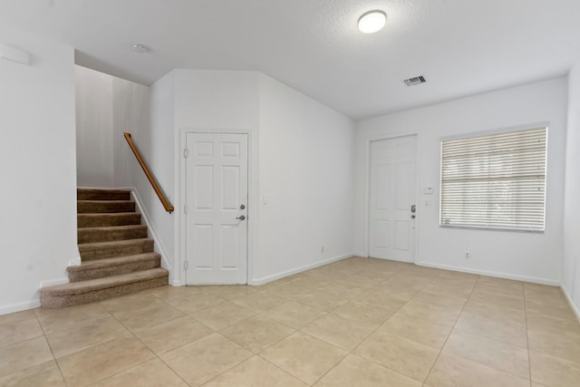 tiled foyer featuring a textured ceiling