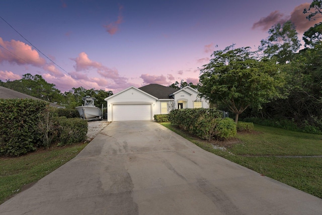 view of front of home featuring a garage and a lawn