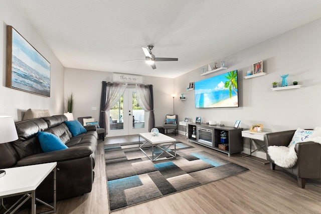 living room with wood-type flooring, a textured ceiling, french doors, and ceiling fan