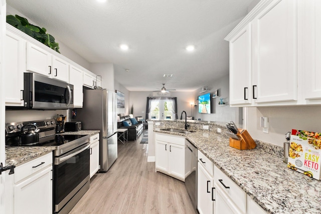 kitchen featuring stainless steel appliances, white cabinetry, ceiling fan, and sink