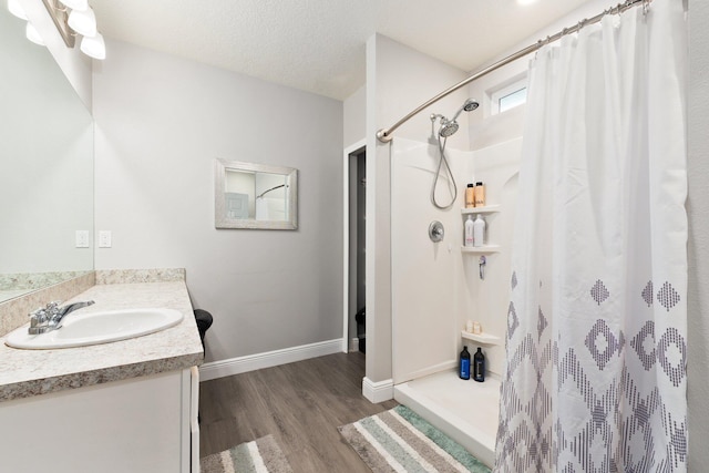 bathroom featuring vanity, a shower with shower curtain, a textured ceiling, and hardwood / wood-style flooring