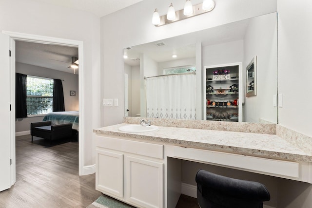 bathroom with curtained shower, ceiling fan, vanity, and wood-type flooring