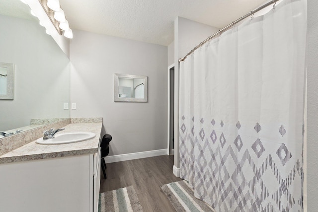 bathroom featuring wood-type flooring, vanity, and a textured ceiling