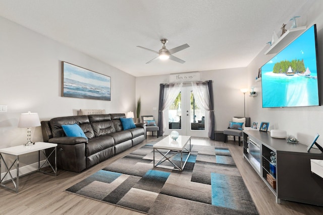 living room with hardwood / wood-style flooring, ceiling fan, and french doors