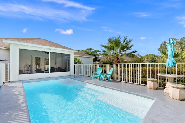 view of swimming pool with a sunroom and ceiling fan