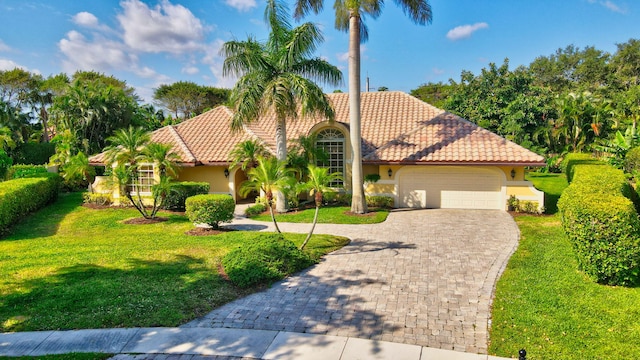 mediterranean / spanish-style home featuring a front yard and a garage