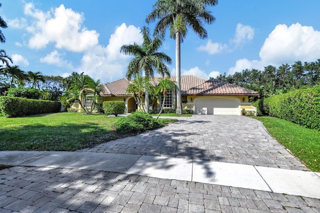 mediterranean / spanish-style home with a front yard and a garage