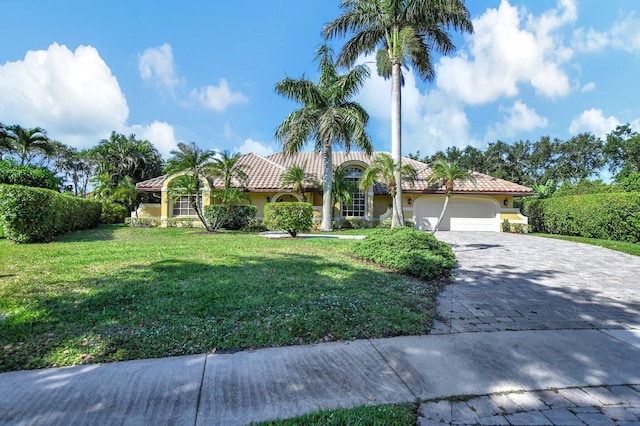 mediterranean / spanish house with a front lawn and a garage