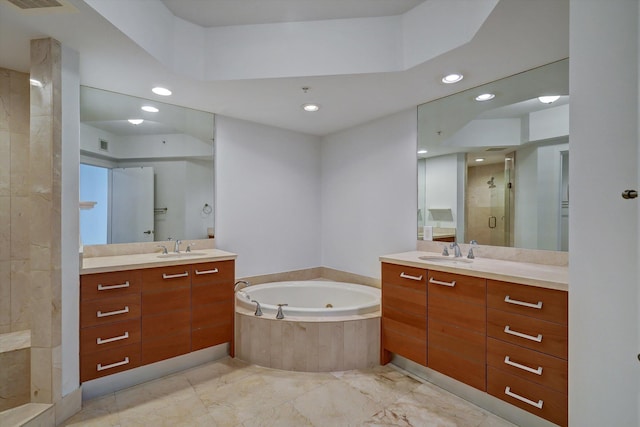 bathroom with vanity and shower with separate bathtub