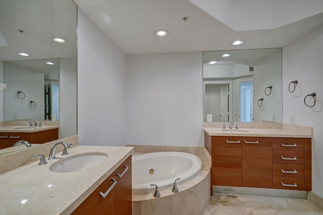 bathroom with vanity and tiled bath