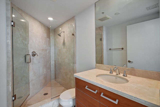 bathroom with toilet, vanity, and walk in shower