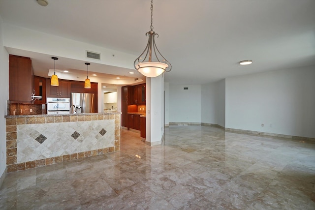 kitchen featuring stainless steel refrigerator with ice dispenser, white oven, and decorative light fixtures