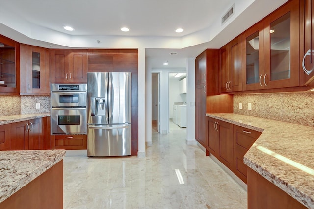 kitchen with light stone counters, appliances with stainless steel finishes, and tasteful backsplash