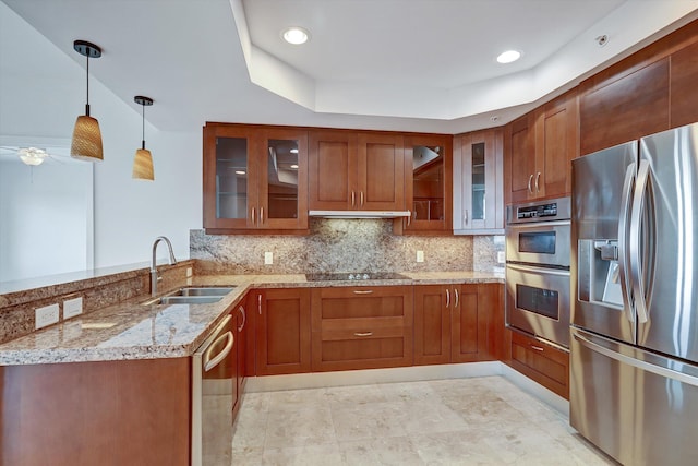 kitchen featuring kitchen peninsula, light stone countertops, pendant lighting, and stainless steel appliances